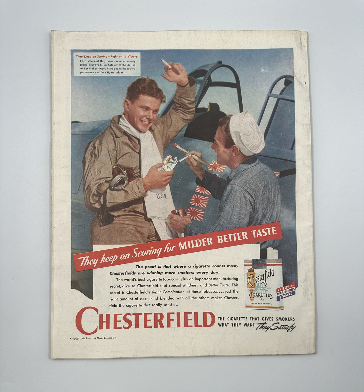 Advertisement page from Woman’s Home Companion Magazine July 1943 for Chesterfield cigarettes, showcasing vintage branding with a military theme.