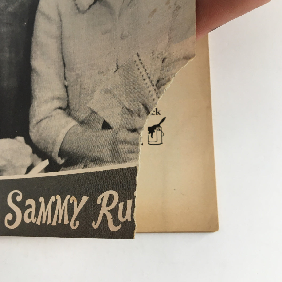 Close-up of the torn edge of the 1965 Playbill for Joseph Cates' What Makes Sammy Run? showcasing its vintage condition.