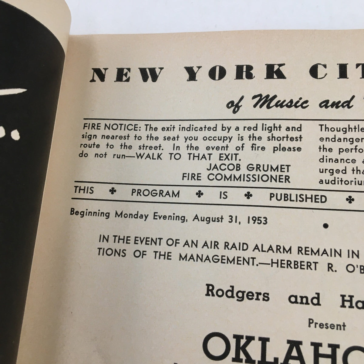 Close-up of a page from the 1953 Playbill for 'Oklahoma!', featuring fire safety information and program publication details from the New York City Center.