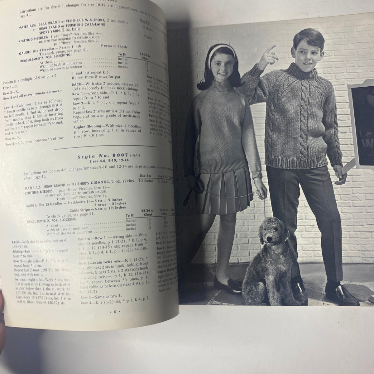 Image from the '1964 Vol. 80 Raglans For Boys and Girls Sweater Vest Catalog' depicting a boy and a girl wearing knitted sweaters, with pattern instructions visible, alongside a brown dog.