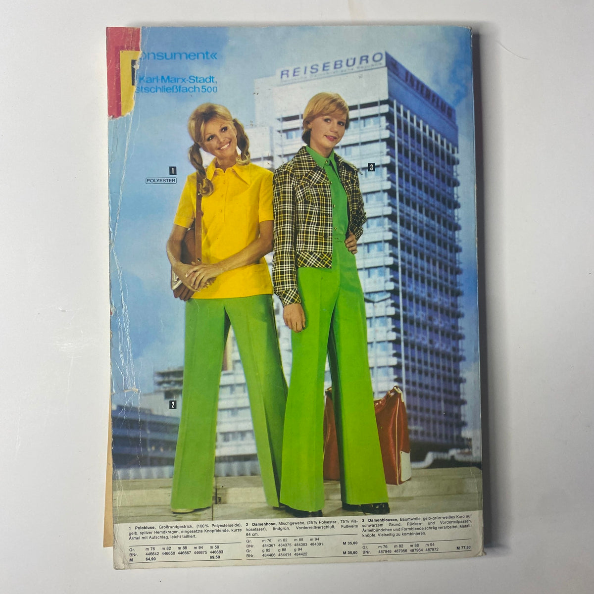 Cover of the 1975 Konsument Summer Catalog showcasing two women in East German fashion. One woman wears a bright yellow top with green pants, while the other models a checkered blazer paired with bright green trousers, set against a backdrop of a modern building.
