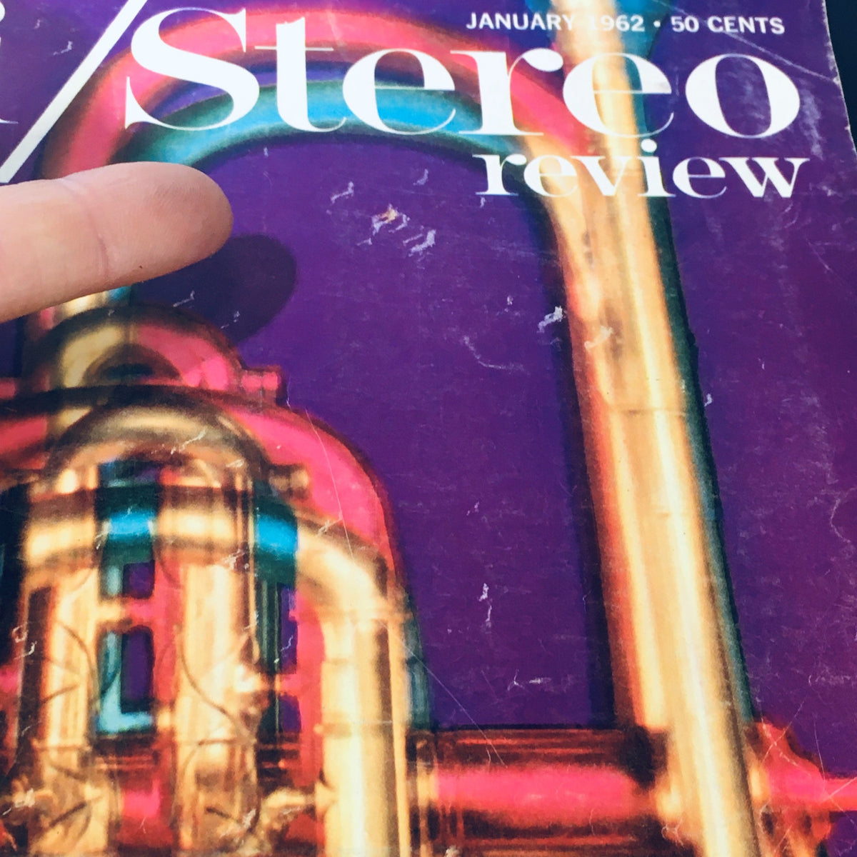 Finger pointing at the cover of VTG HiFi Stereo Review Magazine January 1962, focusing on the vibrant design and title.