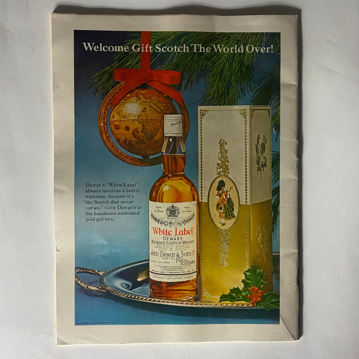 Vintage advertisement for Dewar's White Label Scotch from VTG The Reporter Magazine December 1 1966, featuring a bottle of Scotch in a gift box with holiday-themed decor.