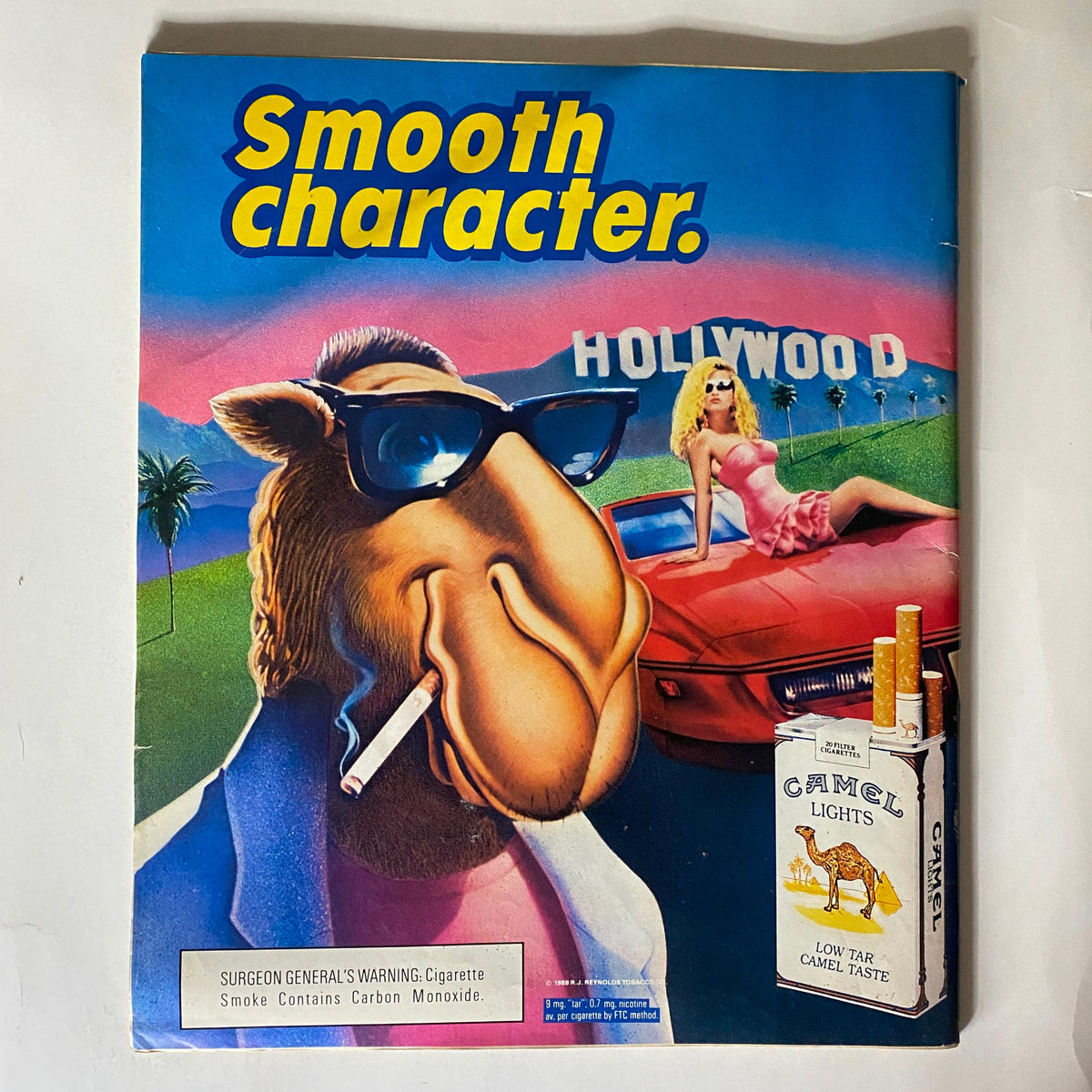 VTG Spin Magazine April 1989 featuring a colorful cover with a camel cartoon character wearing sunglasses, a pink jacket, and holding a cigarette, set against a Hollywood backdrop. Celebrates Madonna and the 4th Anniversary Special.