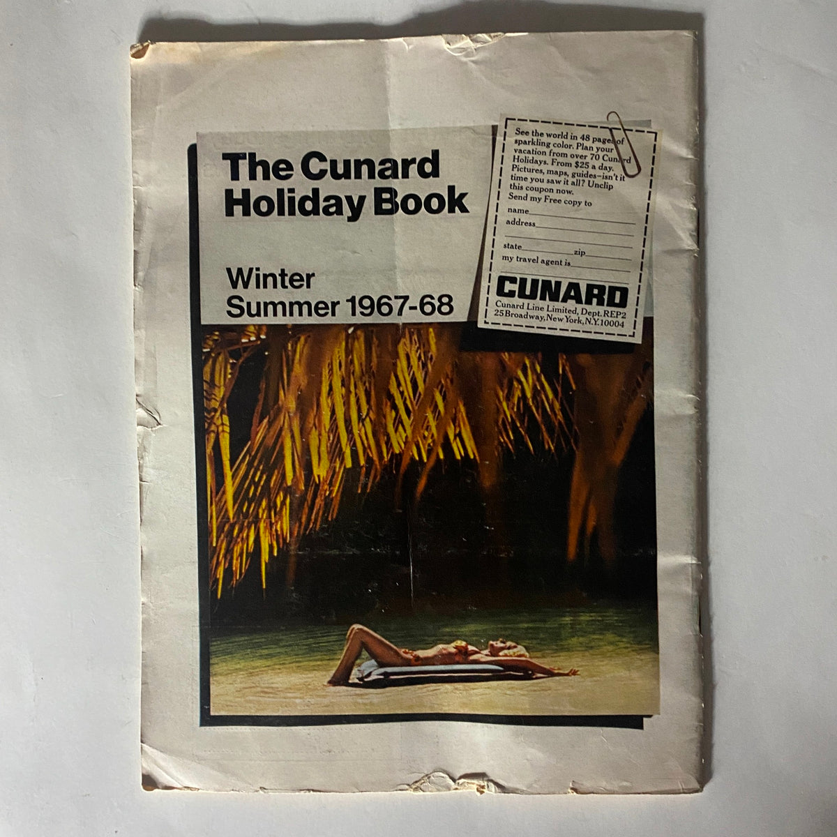 Cover of The Cunard Holiday Book for Winter/Summer 1967-68 featuring a serene beach scene with a person relaxing by the water, showcasing travel opportunities and leisure experiences.