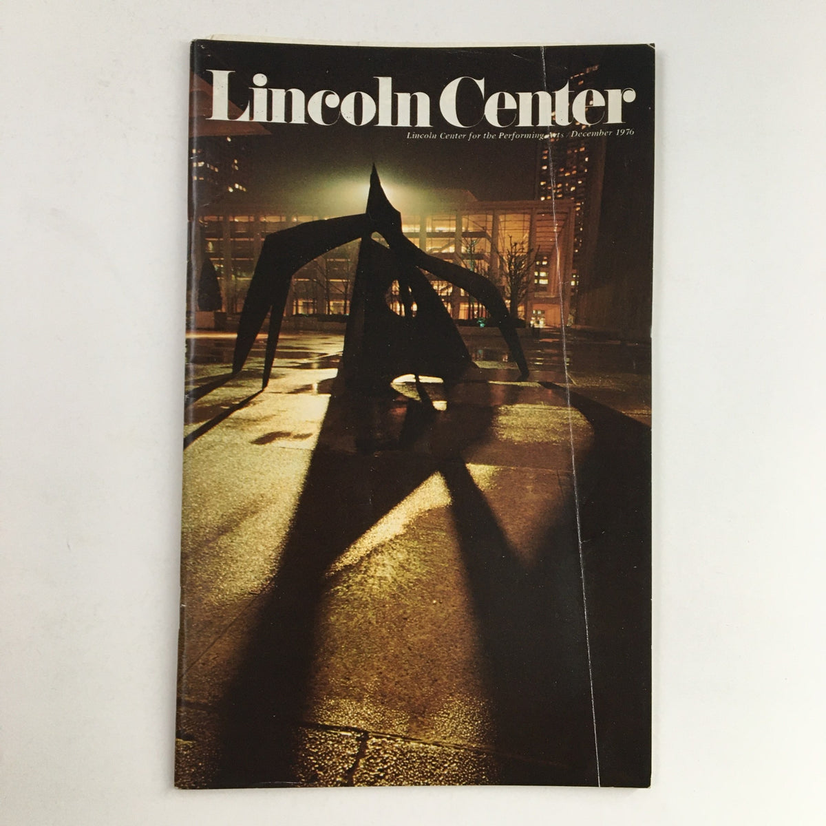 Cover of the 1976 Stagebill featuring Lincoln Center Theatre, presenting Mozart by Marionette, depicting a shadowed sculpture in an urban setting.