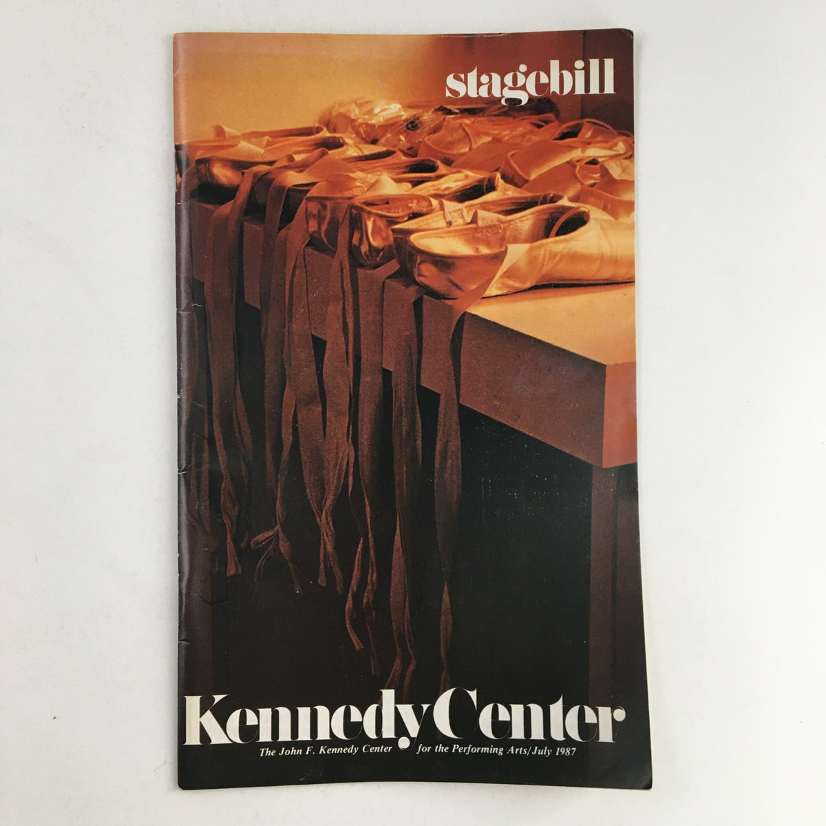 Cover of the 1987 Stagebill titled 'The John F. Kennedy Center Presents The Tango & I by W Livingstone' featuring ballet shoes and ribbons on a table, symbolizing the theatrical performance.