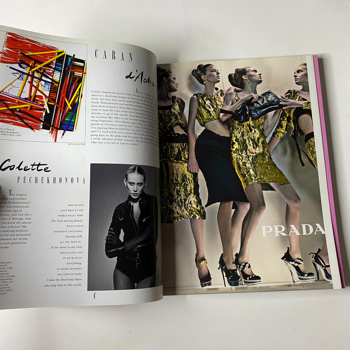 2009 First Love Spring and Summer Catalog showcasing a feature profile on model Colette Pechekhonova alongside a luxury Caran d'Ache advertisement and a Prada fashion advertisement with women in gold-foil textured ensembles.