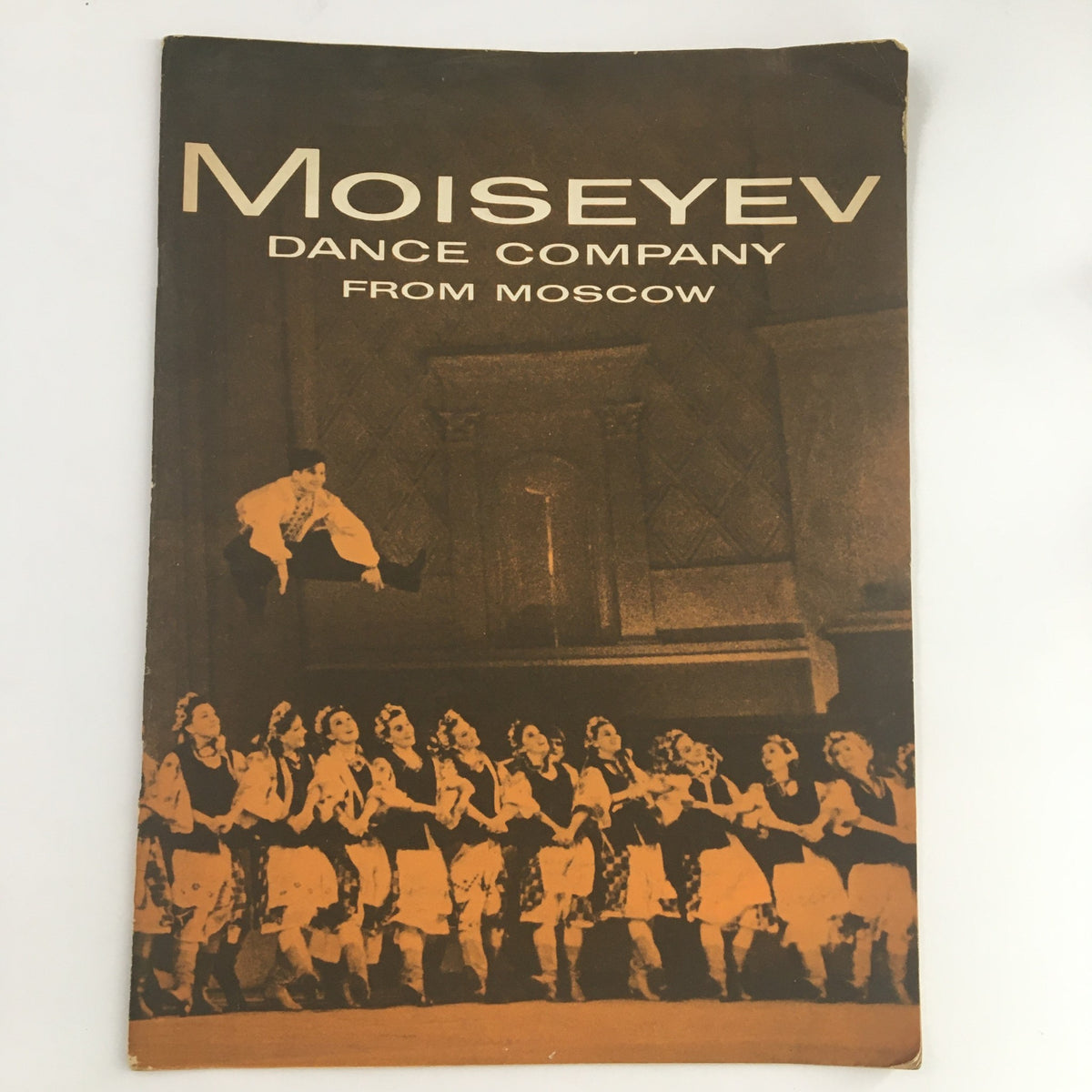 Cover of the 1965 S. Hurok Presents Moiseyev Dance Company from Moscow by Igor Moiseyev, featuring a striking image of a dancer in mid-leap with a group of dancers in traditional costumes.