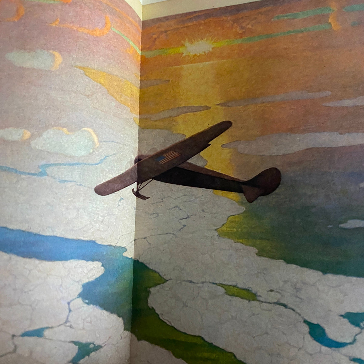 Artistic depiction of an aircraft flying over a colorful abstract landscape from the National Geographic Magazine May 1928 Commander Byrd Supplement.