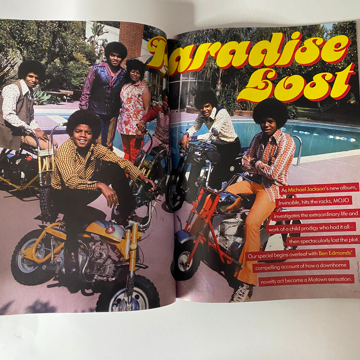 A spread from Mojo Music Magazine December 2001 showcasing Michael Jackson riding a bike with the Jackson 5 in a nostalgic theme titled 'Paradise Lost'.