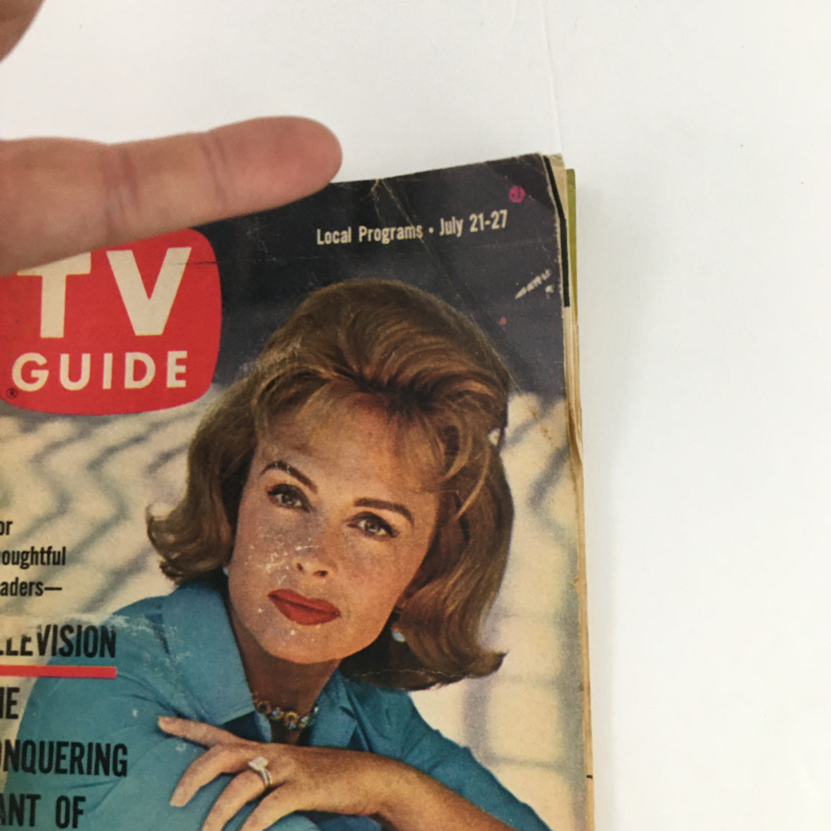 Close-up of TV Guide Magazine cover from July 21, 1962, showcasing the text 'The Conquering Giant of Communications' with hand pointing to the cover details.