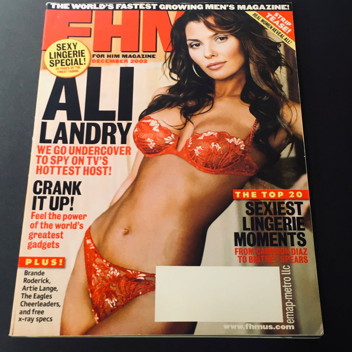 Cover of FHM Magazine December 2002 featuring Ali Landry, highlighted as the hottest TV host. The magazine showcases her in a vibrant red lingerie set, along with additional features on Brande Roderick, sexiest lingerie moments, and top gadgets.