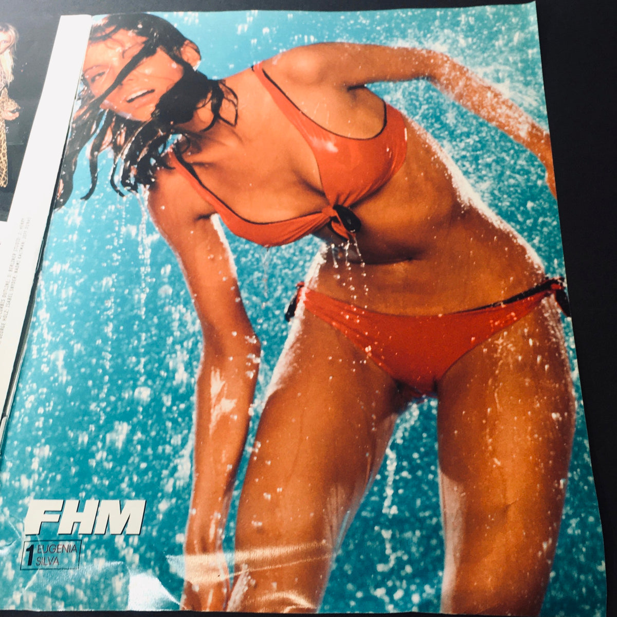 Image from FHM Magazine May 2001 of a model in an orange bikini enjoying water splashes, part of the 50 World's Most Eligible Women feature.