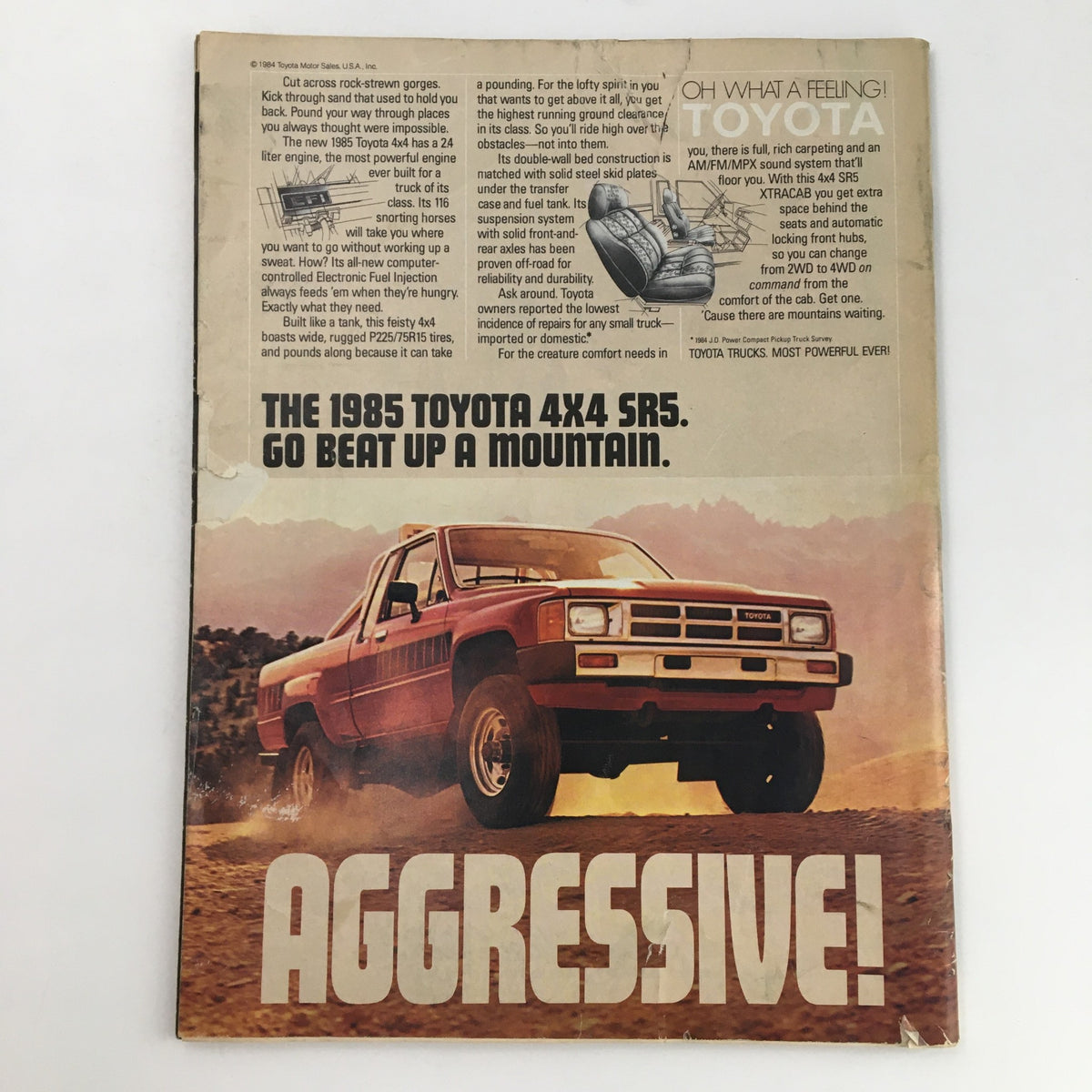 The 1985 Toyota 4x4 SR5 magazine advertisement with the caption "Go Beat Up A Mountain," showcasing a red truck driving off-road, part of the Sports Illustrated Magazine December 10 1984 featuring Michael Jordan.