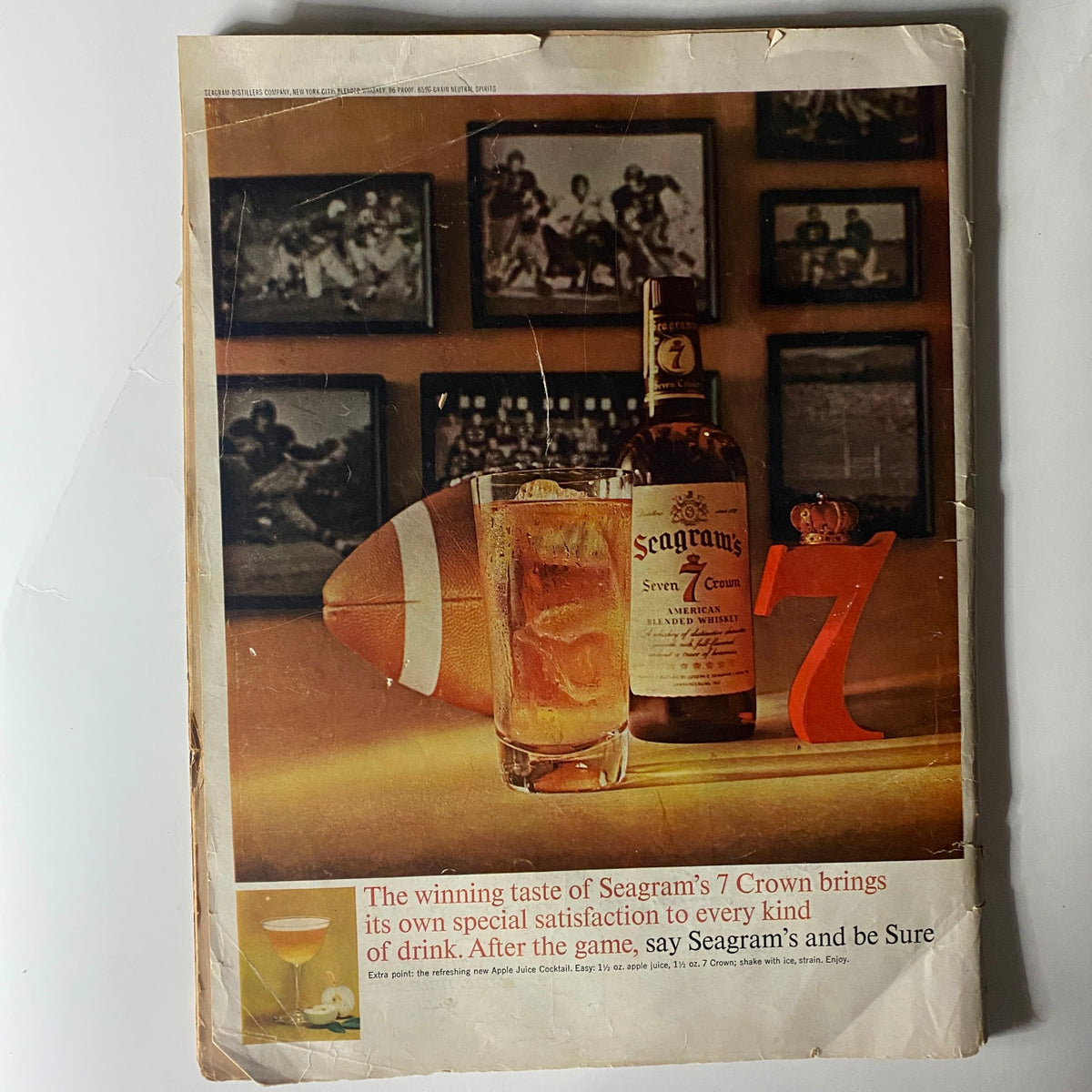 Vintage Ebony Magazine November 1962 featuring an advertisement for Seagram's 7 Crown whiskey with a frosty drink, a football, and a stylish '7' display. The backdrop includes framed sports photographs, highlighting the iconic era of American history.