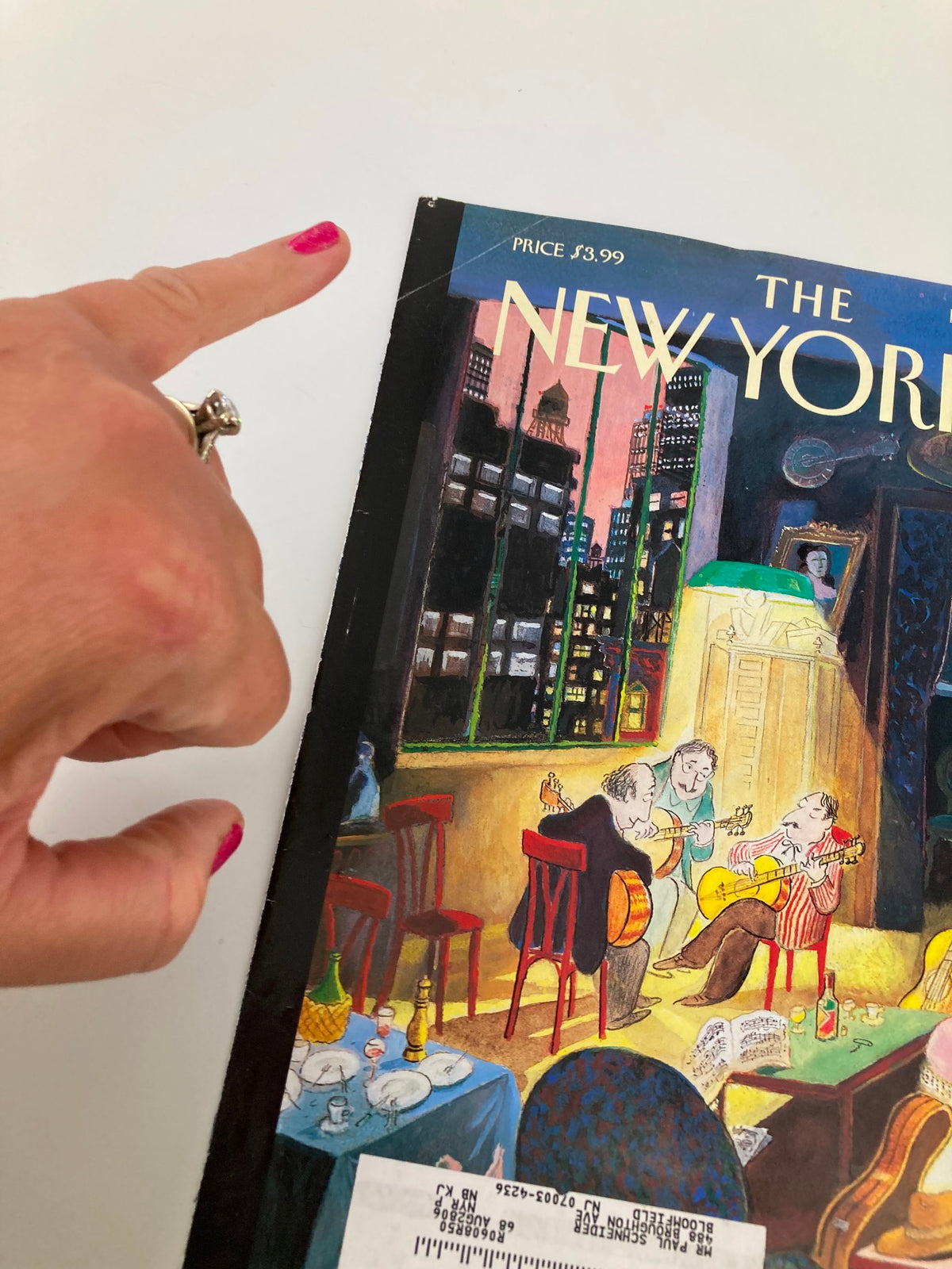 Close-up of the March 13, 2006 cover of The New Yorker titled 'Three Amigos' by Jean-Jacques Sempe, showing part of the cover design and a finger pointing at the magazine.