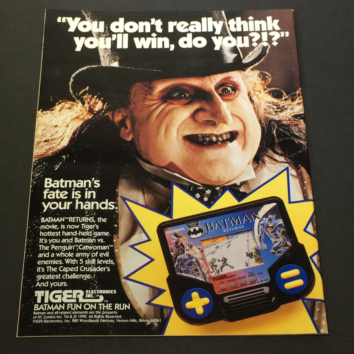 Promotional page from the Topps Official Movie Souvenir Magazine 1992 featuring The Penguin from Batman Returns, advertising a Tiger Electronics handheld game.