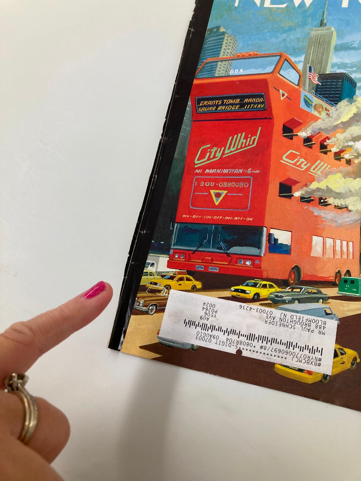 Detail of The New Yorker July 20 2009 Tour Wars Cover showcasing a hand pointing at the City Whid advertisement on the bus.
