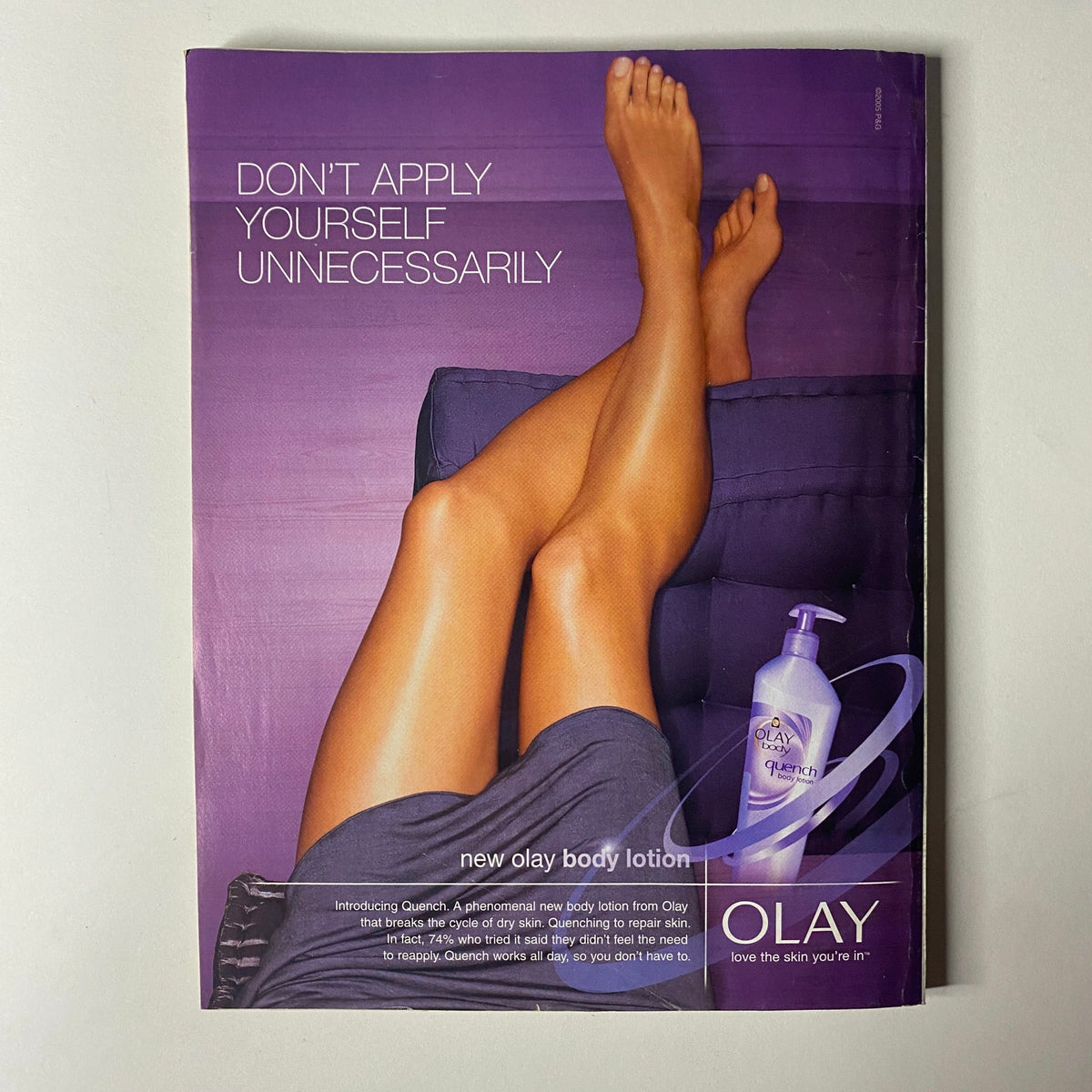 Olay body lotion advertisement featuring a woman's legs resting with the text 'Don't Apply Yourself Unnecessarily' in the June 2005 issue of Redbook Magazine with Tim McGraw on the cover.