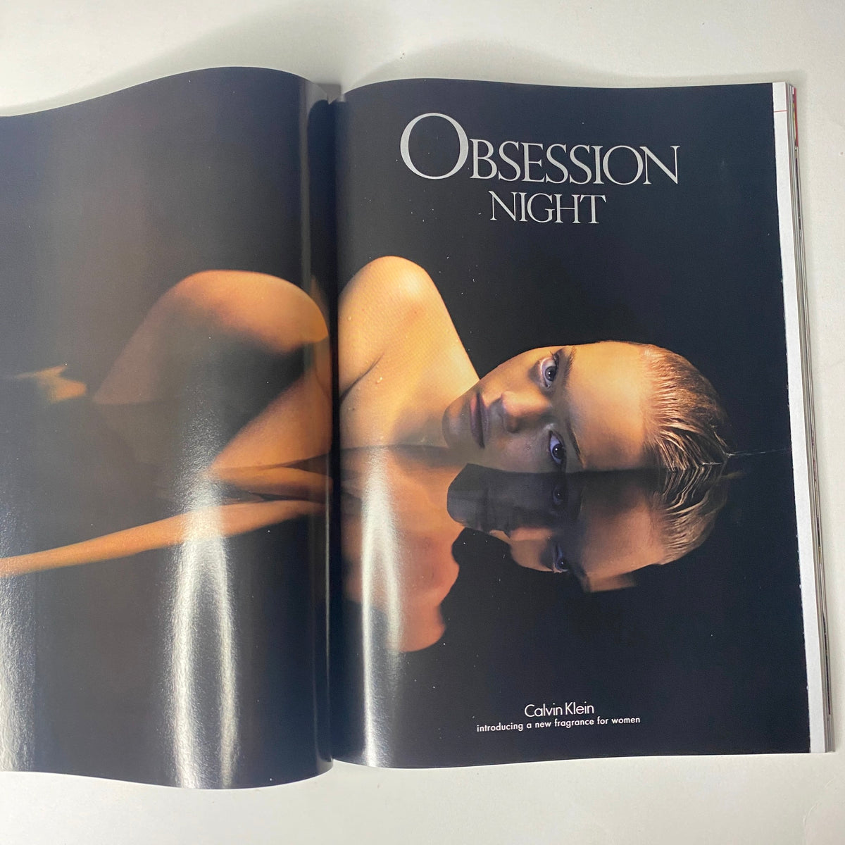 Calvin Klein's 'Obsession Night' fragrance ad from Vogue Magazine August 2005, featuring a striking model to promote the scent.