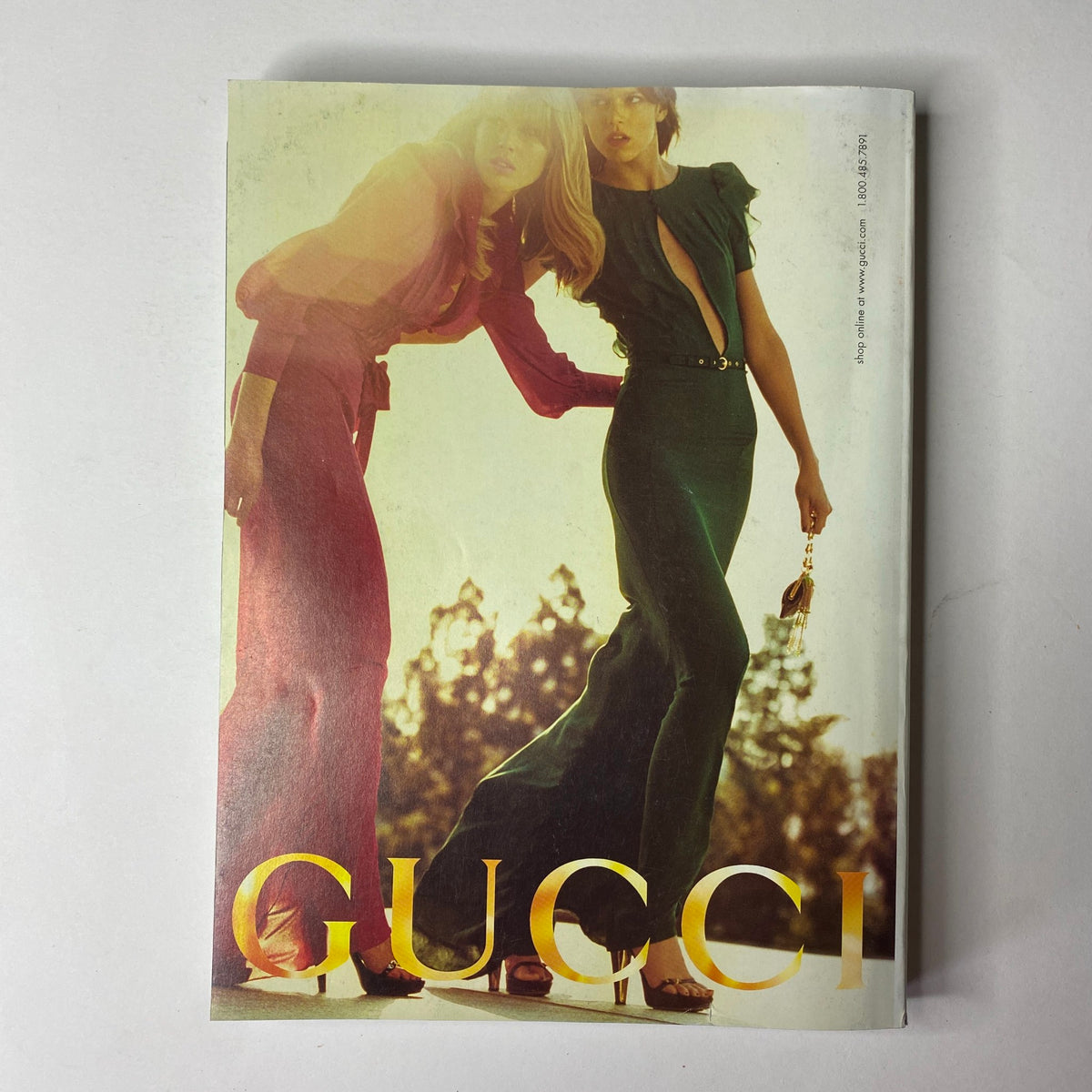 Advert page from Vogue Magazine March 2006 featuring a Gucci fashion advertisement with models in elegant dresses.