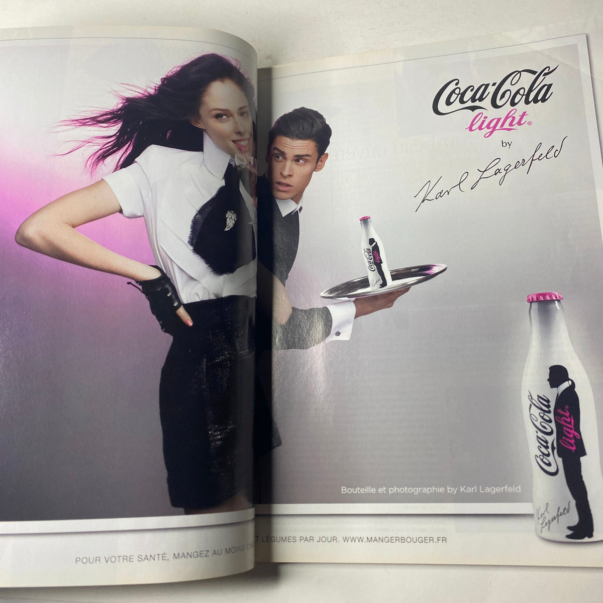 An advertisement from Vogue Paris Magazine June - July 2010 No. 908 for Coca-Cola Light, featuring a stylish model in a black and white outfit, showcasing Karl Lagerfeld's photography.
