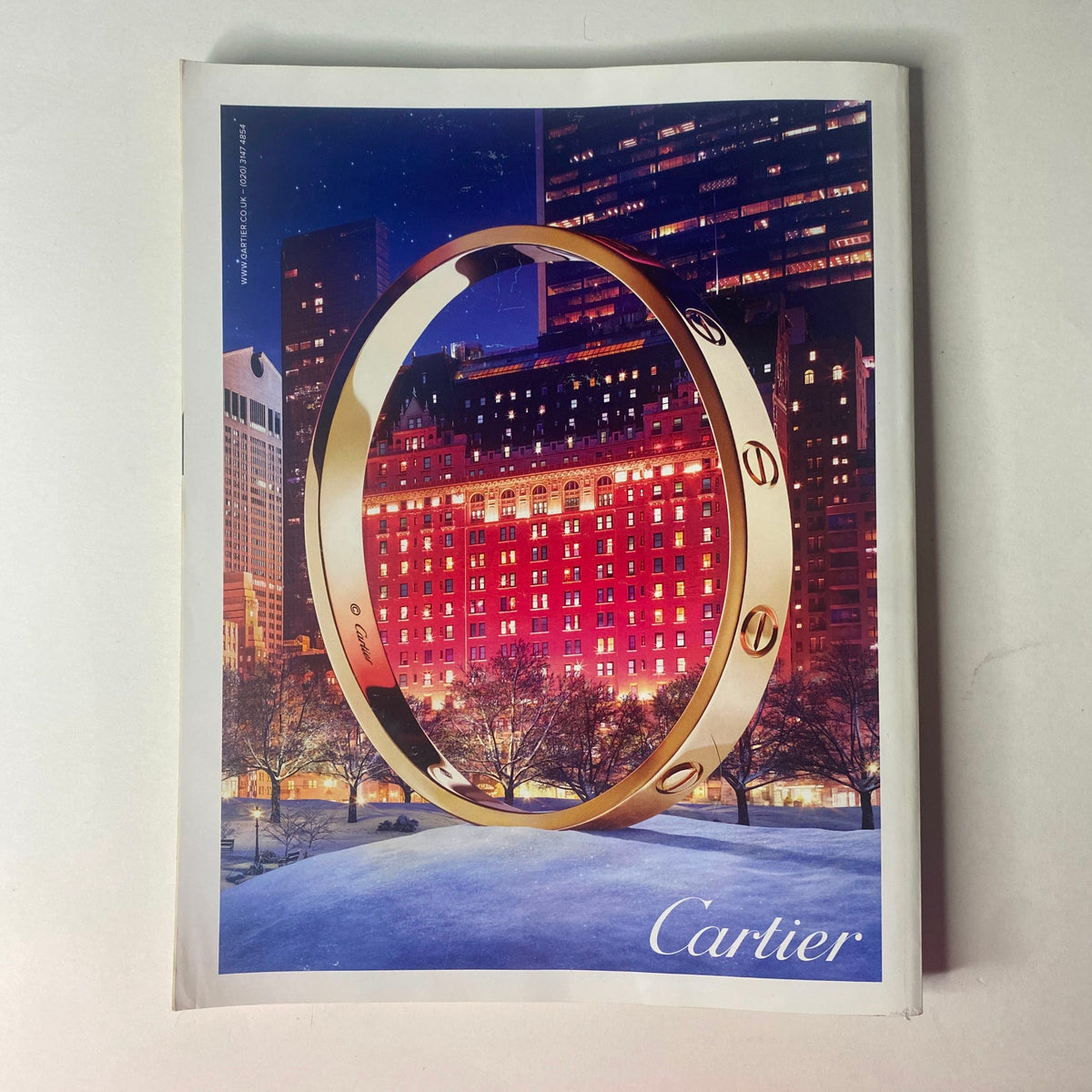Vogue British Magazine January 2017 features an advertisement for Cartier, showcasing a luxurious bracelet against a backdrop of illuminated city buildings at night.