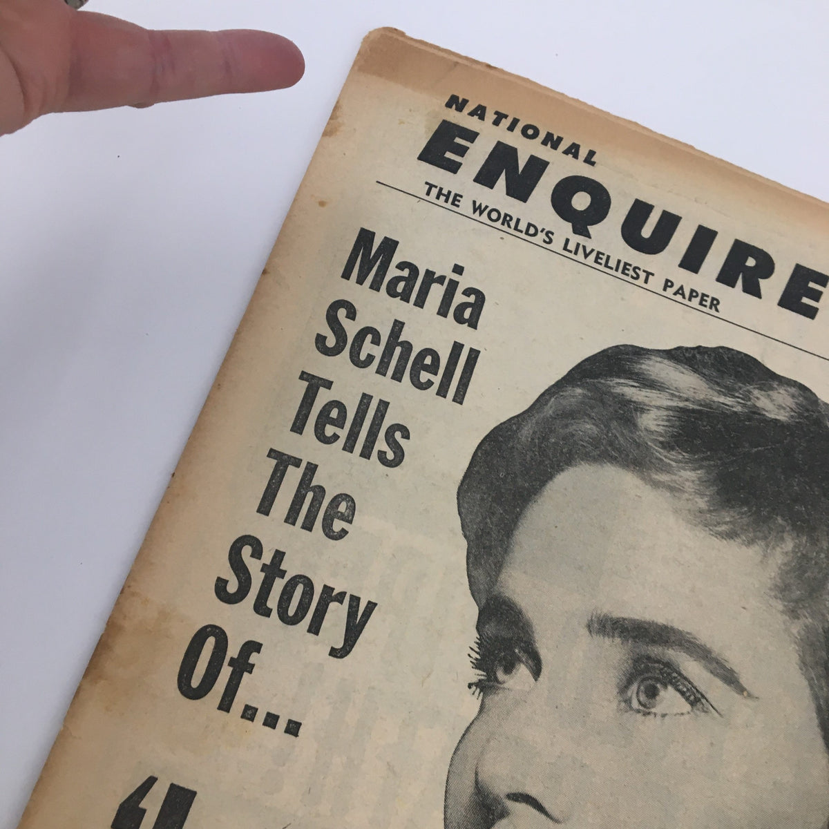 Close-up of National Enquirer Paper September 4 1960 highlighting Maria Schell's headline 'Love, Oranges And Me' and a hand pointing to the text.