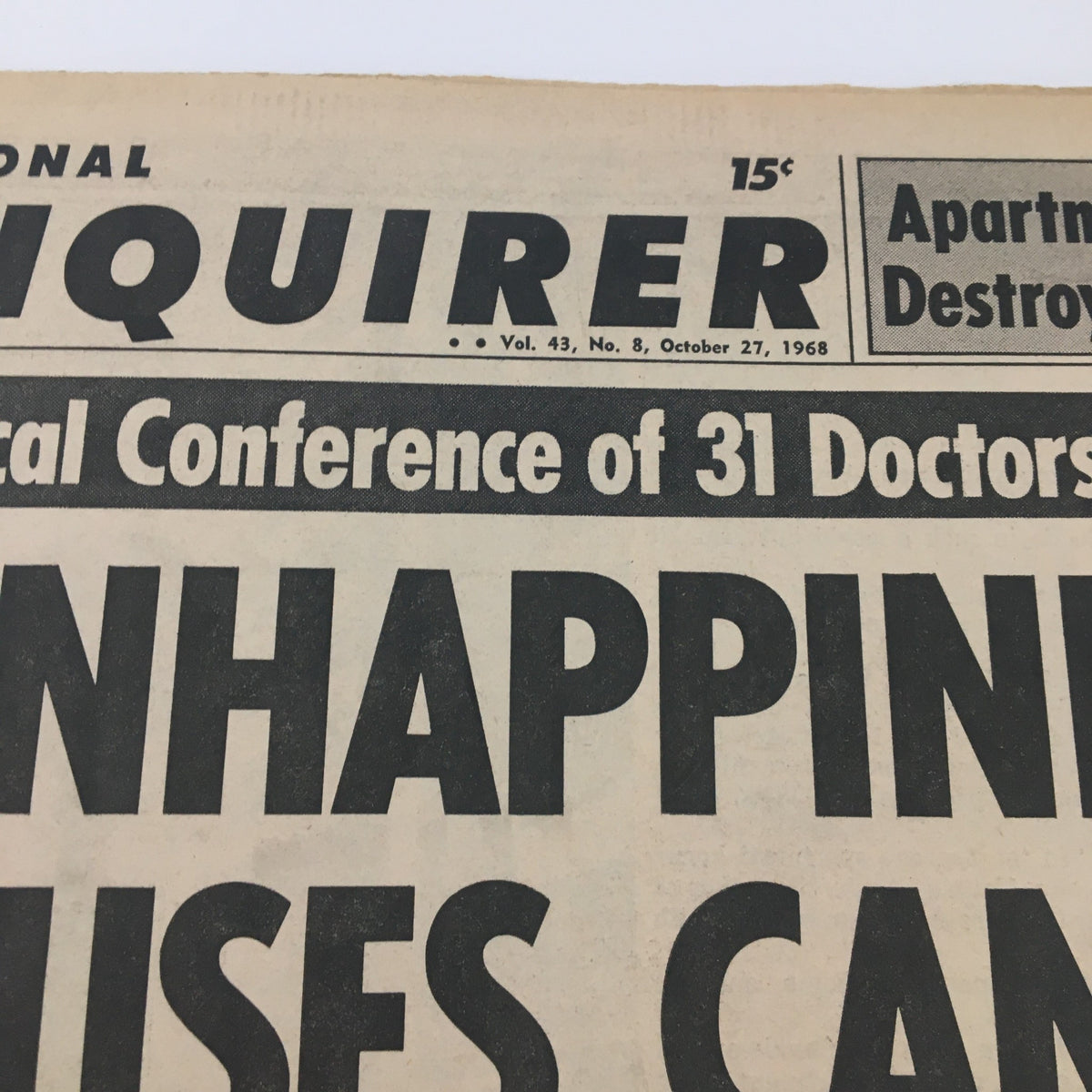 Close-up of the National Enquirer newspaper title from October 27, 1968, highlighting a report on unhappiness causing cancer and its associated medical insights.
