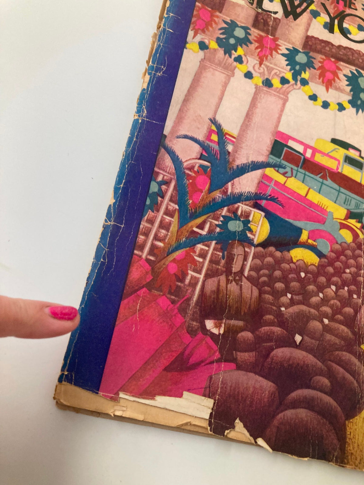 Detailed view of the side of The New Yorker Magazine January 5, 1929, showcasing wear and tear, with a finger pointing at a crack, emphasizing the magazine's age and collectible status.