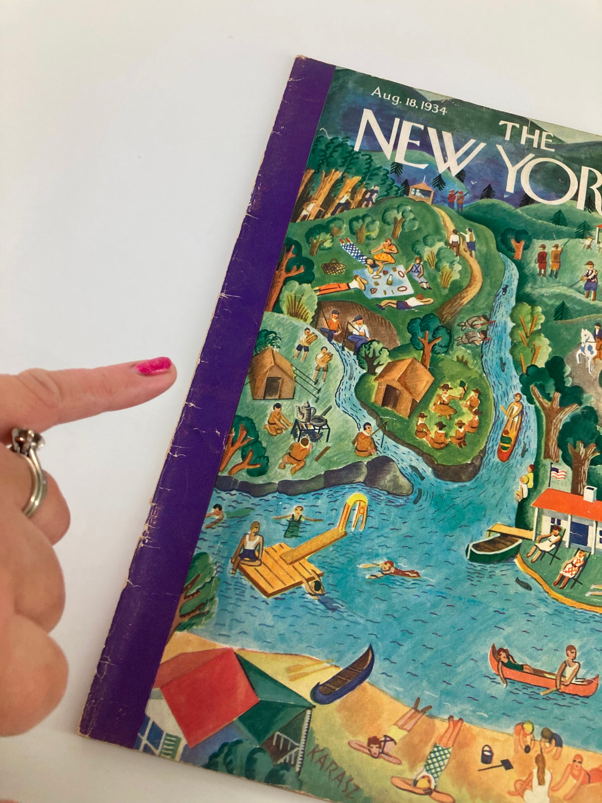 Side view of The New Yorker Magazine August 18 1934 showcasing the cover art depicting summer recreation, with a hand pointing at the magazine.