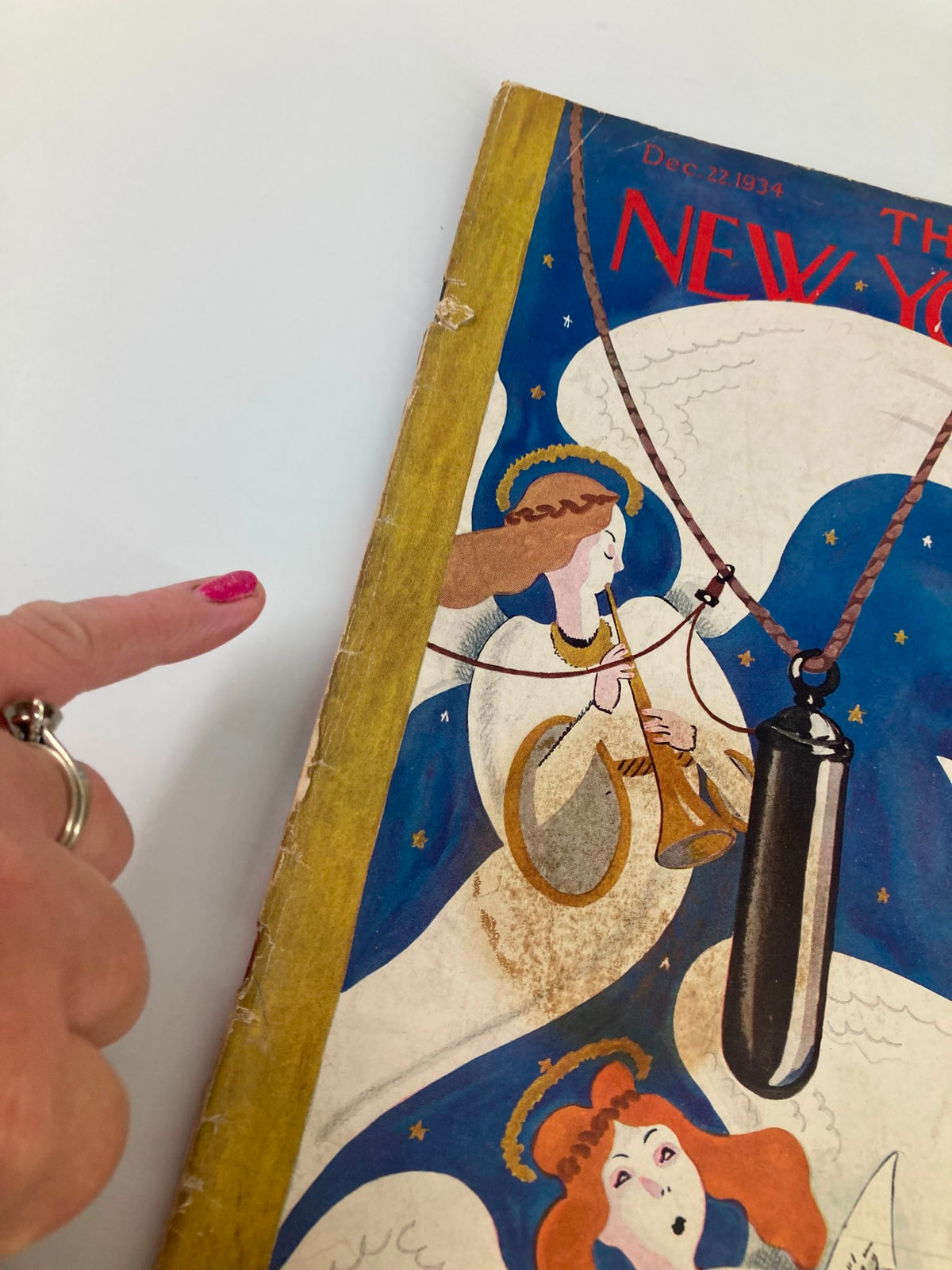 Close-up view of The New Yorker Magazine December 22, 1934 cover, highlighting the edge with minor wear and an angel playing a musical instrument.
