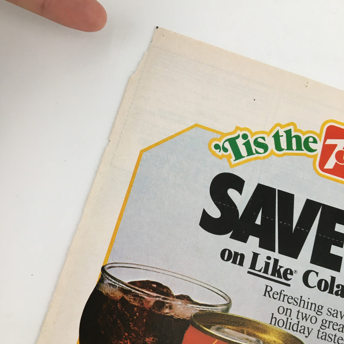 Close-up of the 1984 7-Up Season & Like Cola Circular Coupon Advertisement showcasing the text 'SAVE 25¢ on Like Cola' with a festive design.