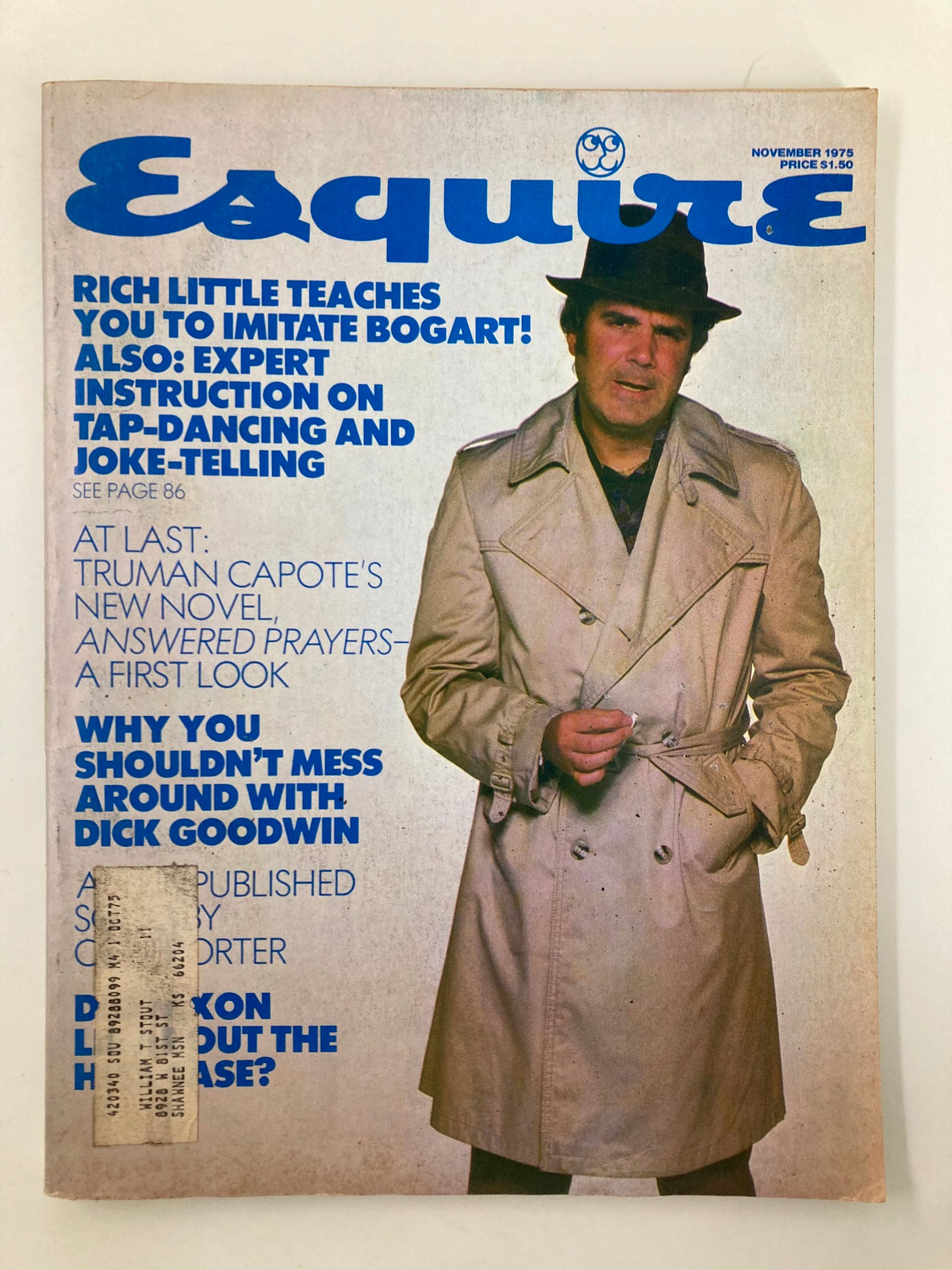 Cover of VTG Esquire Magazine from November 1975 featuring the title 'Esquire' in bold blue lettering. The magazine highlights Truman Capote's novel 'Answered Prayers' with a prominent photograph of a man in a beige trench coat, reflecting the fashion and culture of the 1970s.