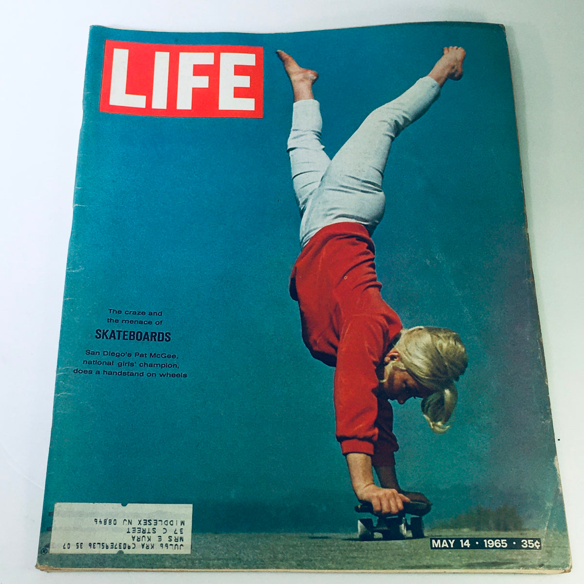Cover of VTG Life Magazine May 14, 1965, featuring the headline 'The Craze and Menace of Skateboards'. The image showcases a young girl performing a handstand on a skateboard, highlighting the emergence of skateboarding culture in San Diego.