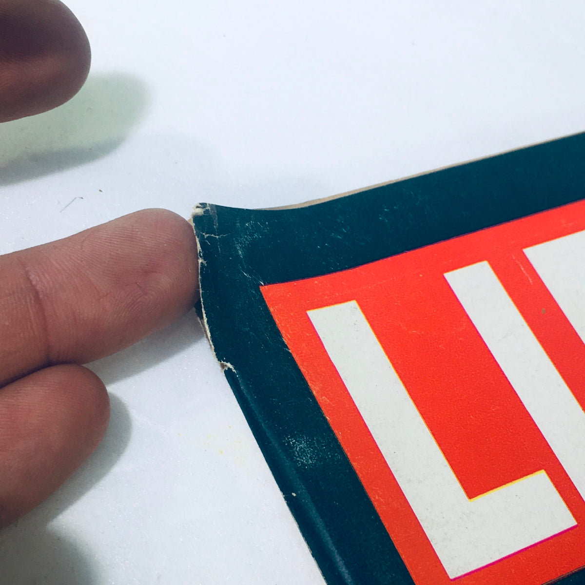 Close-up of the corner of a vintage Life Magazine from April 13, 1962, featuring the title 'LIFE' with visible wear, highlighting the magazine's used condition.