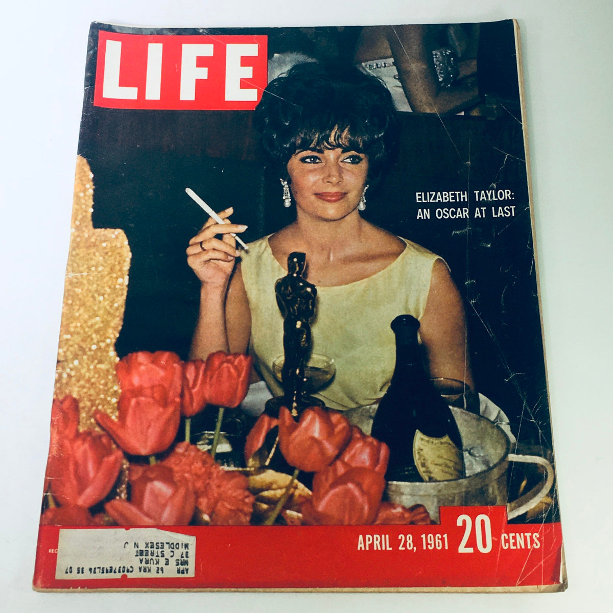 Cover of VTG Life Magazine from April 28, 1961 featuring Elizabeth Taylor holding an Oscar award, surrounded by flowers and a celebratory atmosphere.