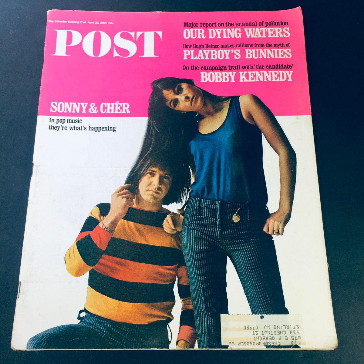 Cover of VTG The Saturday Evening Post from April 23, 1966 featuring Sonny & Cher in striking outfits, highlighting cultural icons alongside the legacy of Bobby Kennedy. A collectible magazine reflecting the 1960s era.