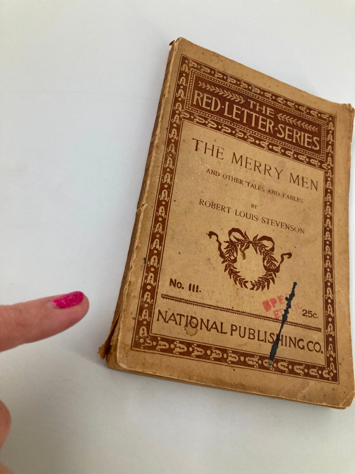 Side view of The Red-Letter Series No. III The Merry Men and Other Tales and Fables, highlighting wear and tear on the cover and spine.