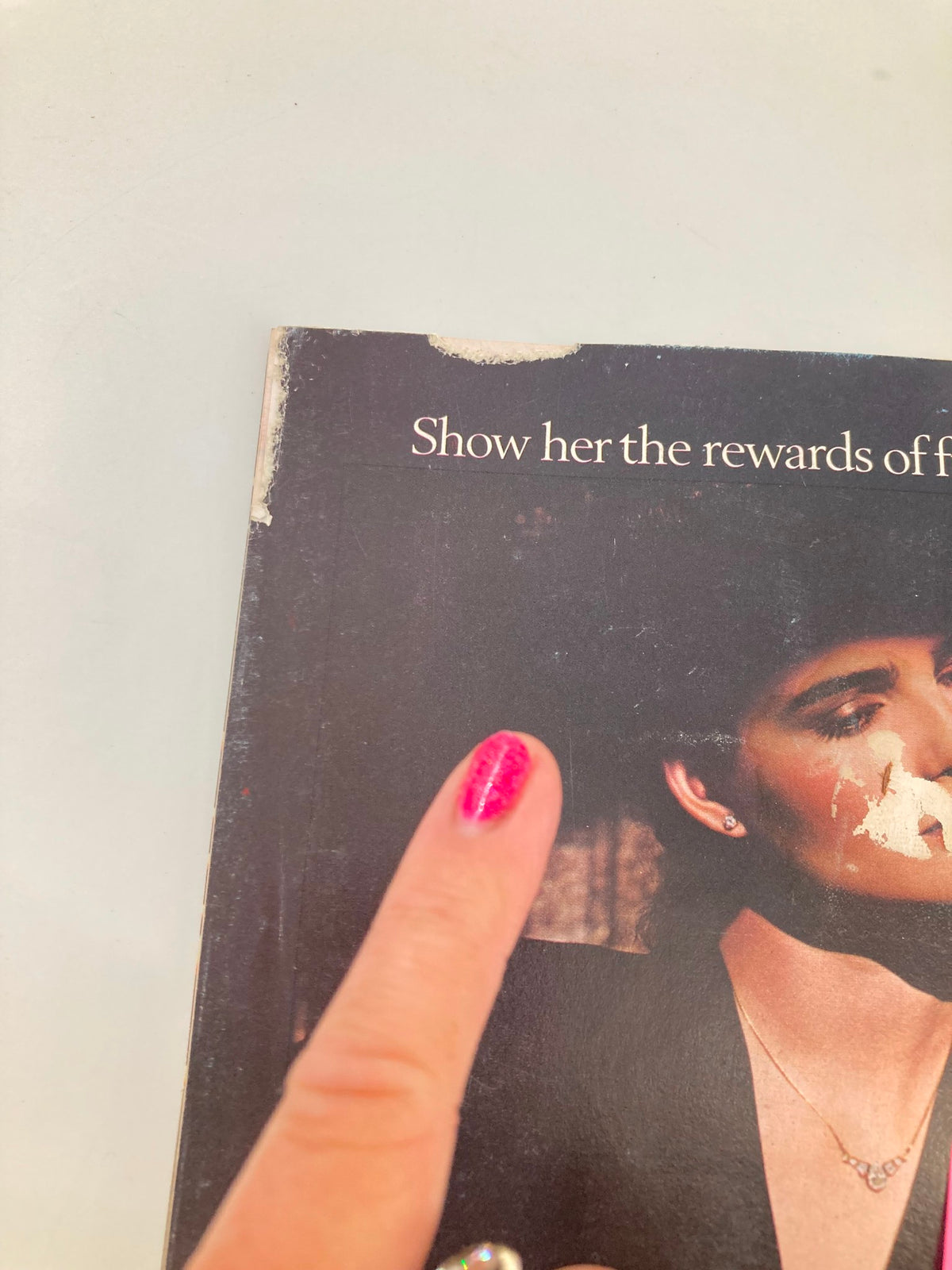 Close-up image of the back cover of Vanity Fair magazine from July 1984, with a partially obscured text reading "Show her the rewards of..." indicating vintage magazine wear.