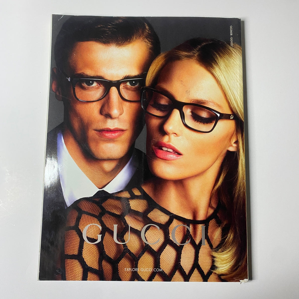 Inside Harper's Bazaar UK Magazine May 2013 displaying a Gucci advertisement featuring a glamorous couple wearing glasses, emphasizing high-fashion styles and modern romance.