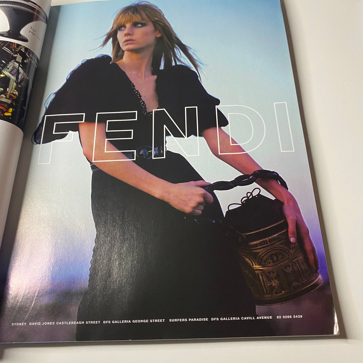 Fendi advertisement featuring a model holding a decorative lantern, from Harper's Bazaar Australia December 2006 issue with Kirsten Dunst on the cover.