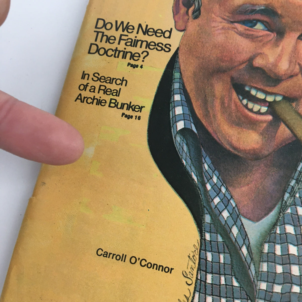 Close-up of the cover of TV Guide Magazine August 30, 1975, showcasing Carroll O'Connor with a cigar. The magazine features titles like 'Do We Need The Fairness Doctrine?' and 'In Search of a Real Archie Bunker.' This highlights O'Connor's prominence in television history.