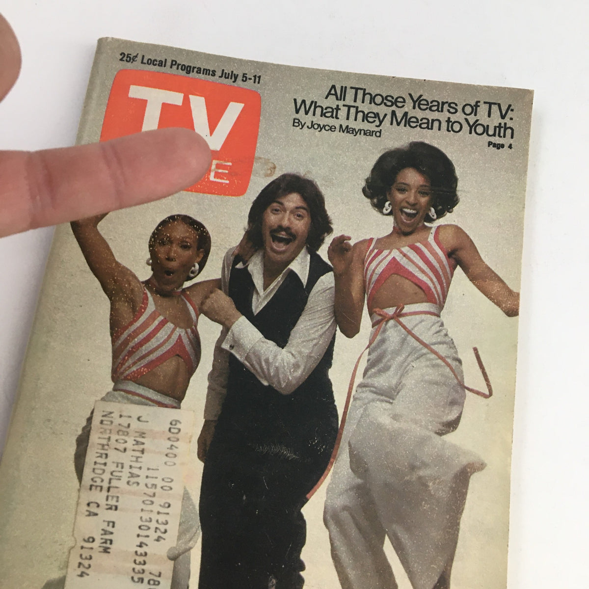 Close-up of TV Guide Magazine July 5 1975 cover revealing Tony Orlando and Dawn with a hand pointing at the title, emphasizing TV show nostalgia.