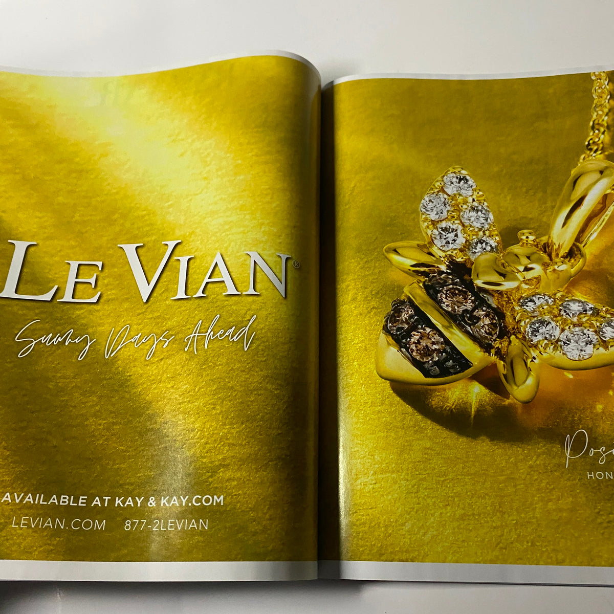 Le Vian jewelry advertisement showcasing a bee-themed pendant on a gold background in Harper's Bazaar Magazine April 2022 featuring Renée Zellweger. Promotes spring-inspired designs.