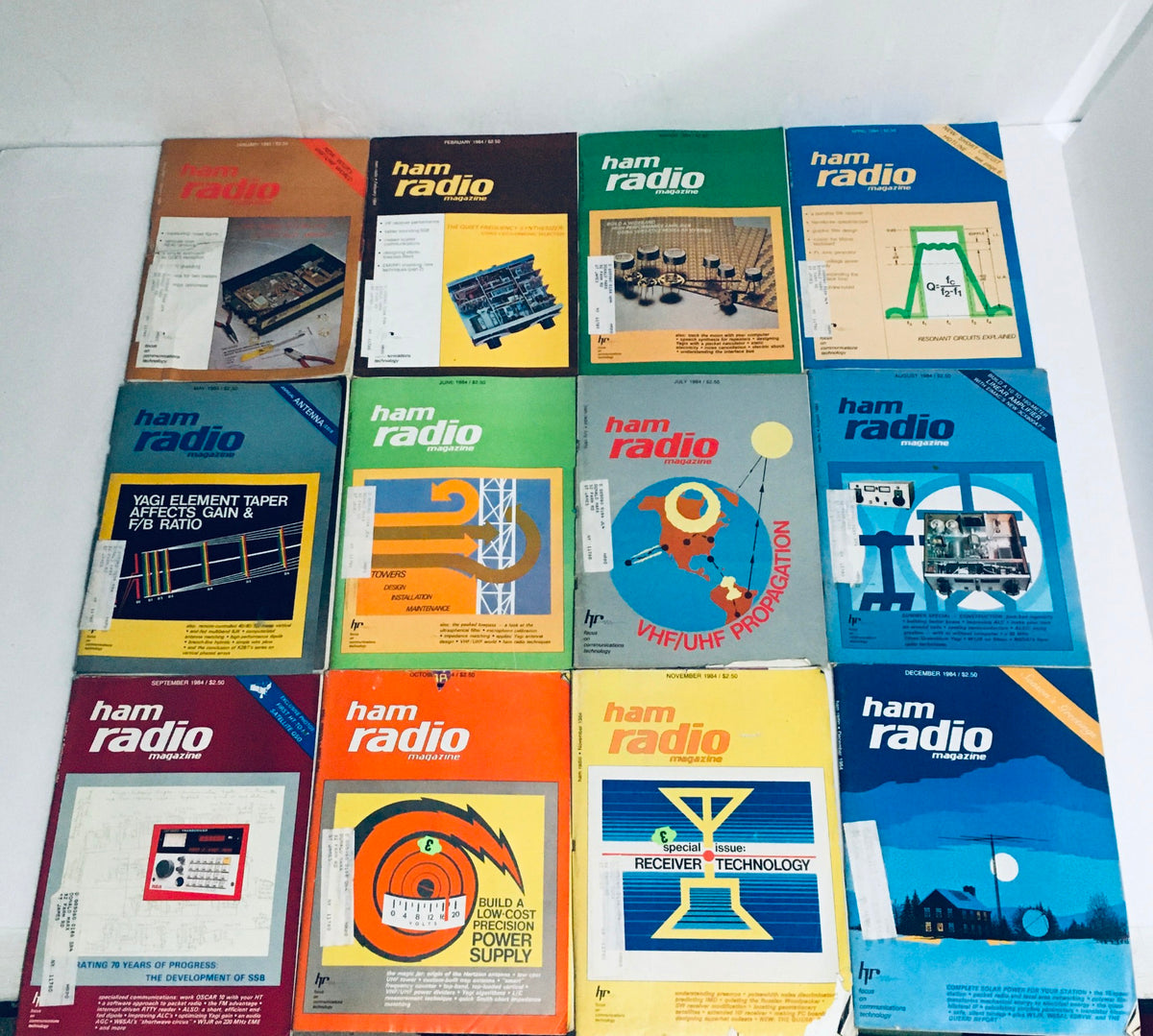 Lot of 12 Complete January to December 1984 Ham Radio Volume 1 to 12, showcasing a collection of vintage ham radio magazines with illustrations and technical information.