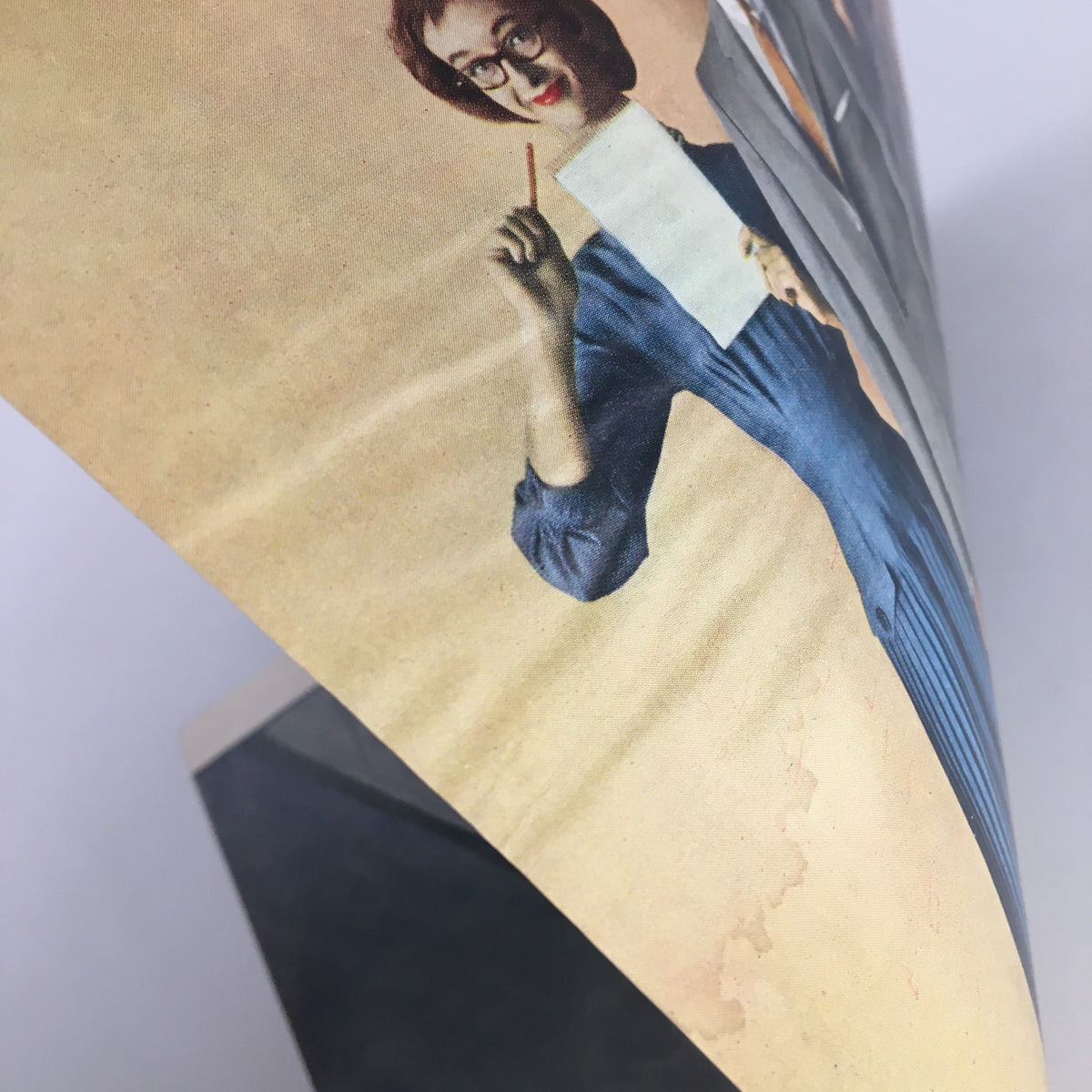 Detail view of The New Yorker cover from March 16, 1957, showing a woman in a blue dress holding a paper, part of the thematic design by Arthur Getz.