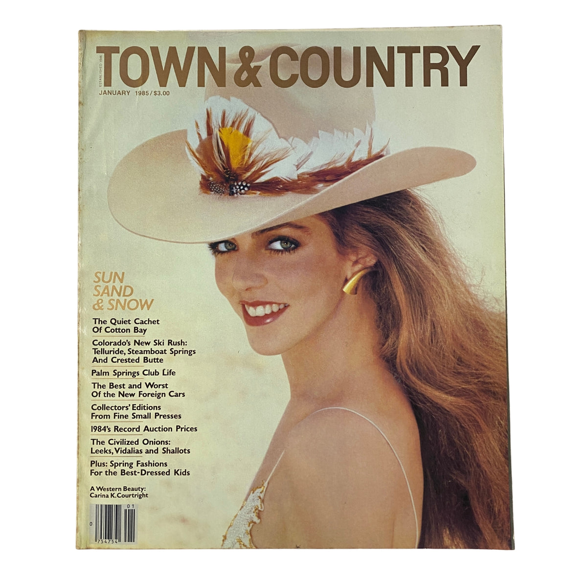 Town & Country Magazine January 1985 cover featuring Carina K. Courtright, showcasing a cosmopolitan beauty in a stylish hat and gown.