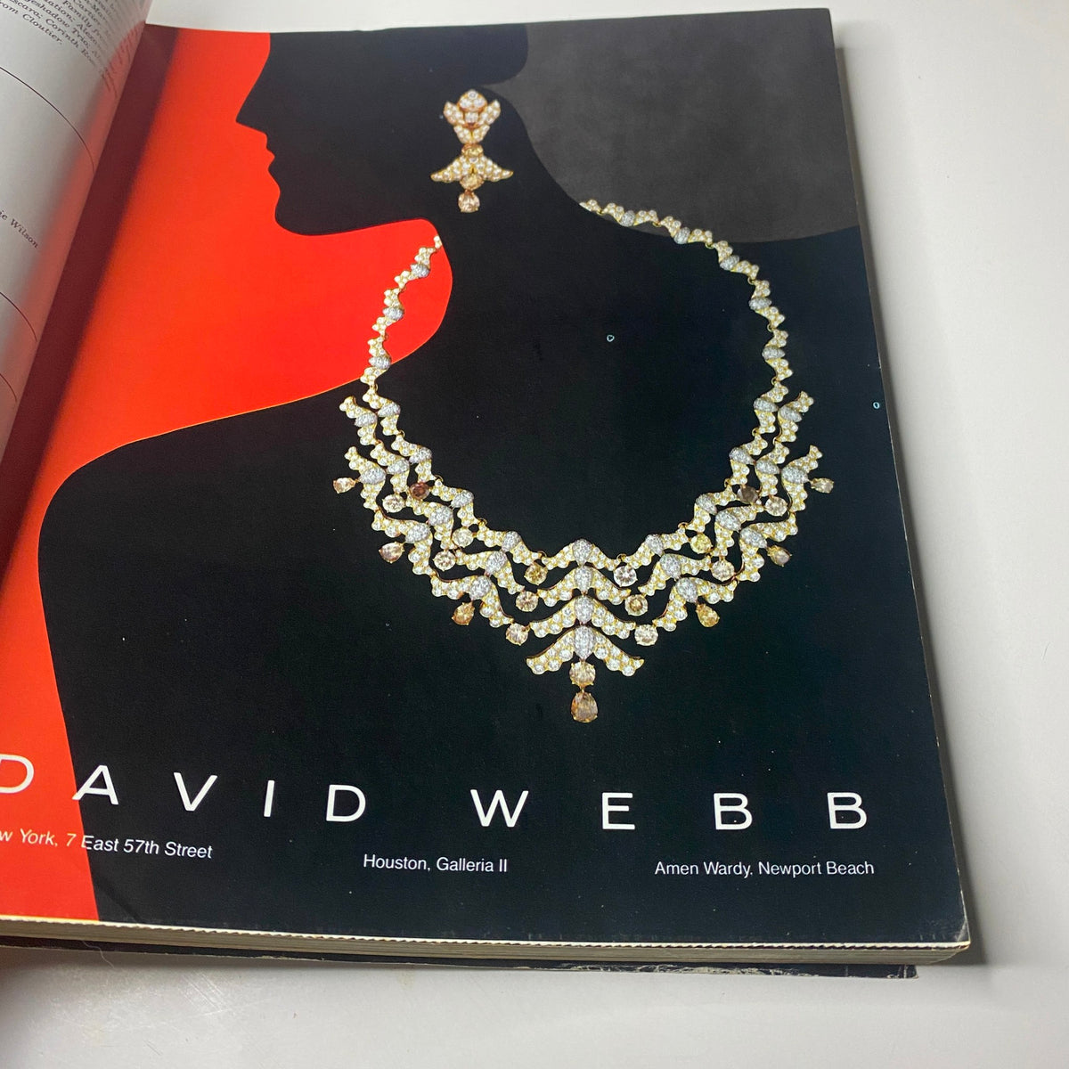 An advertisement for David Webb jewelry featured in Town & Country Magazine November 1985, showcasing luxurious earrings and a statement necklace against a bold red background.